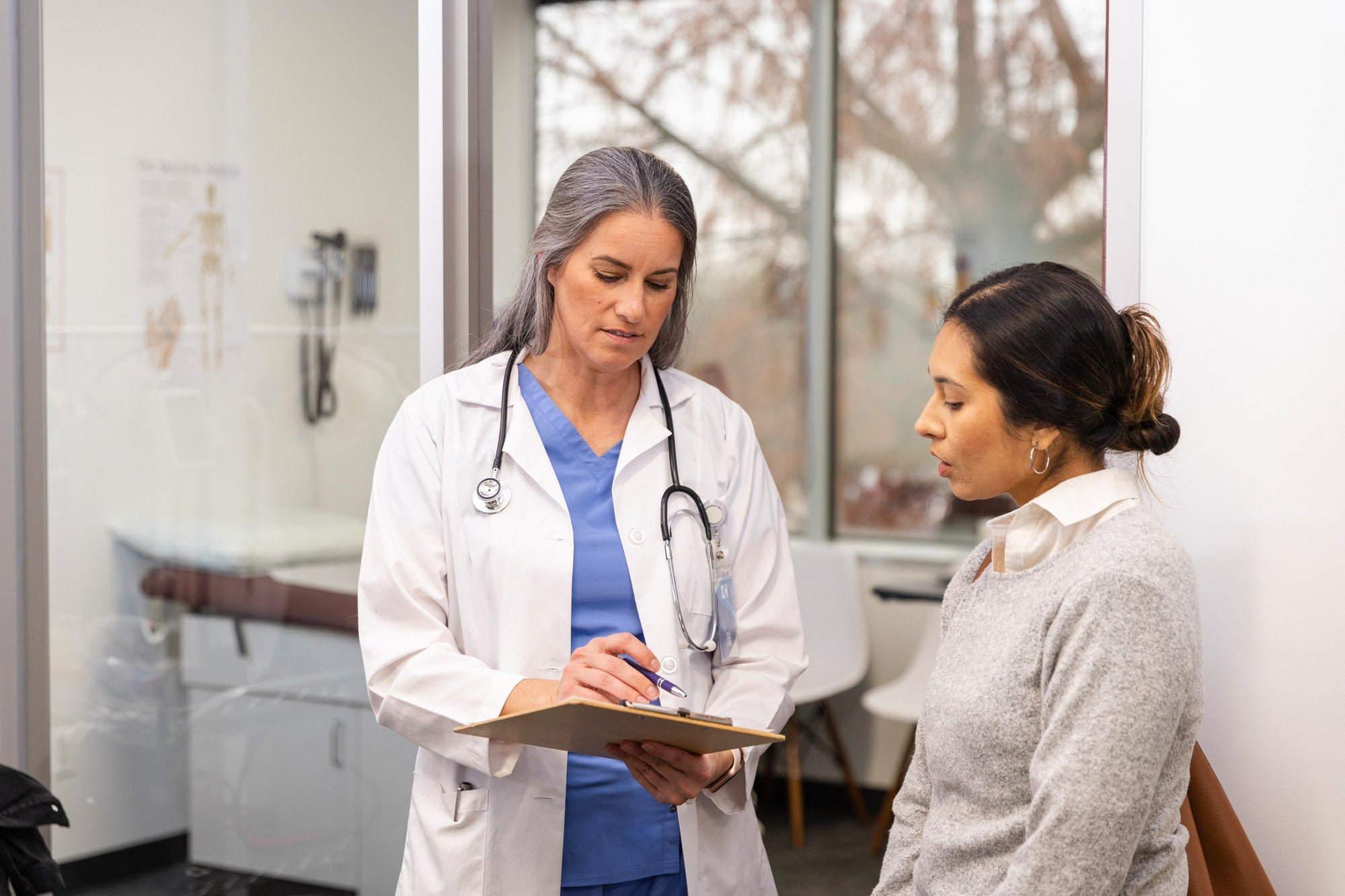The serious mature adult female doctor gives the mid adult woman some bad news about the medical test results.