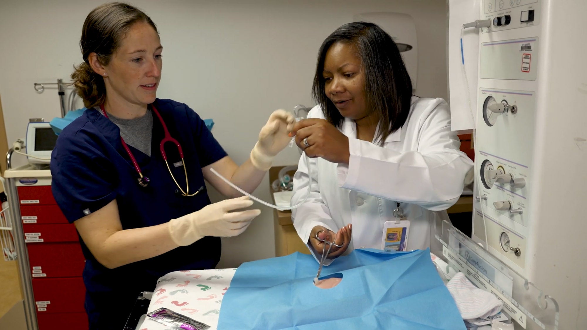 Female doctor and female nurse work together on a pediatric training procedure