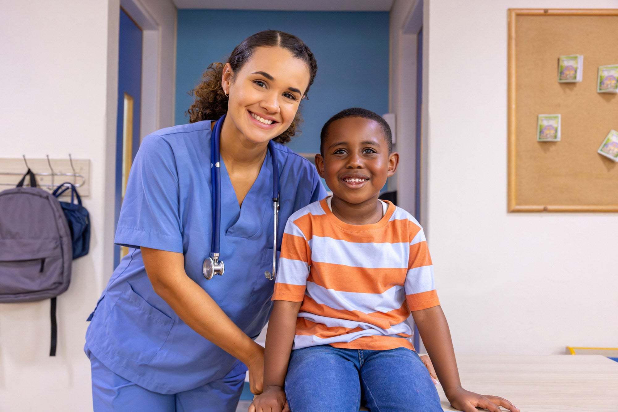 Portrait of a happy school nurse with boy smiling at the office - healthcare and medicine concepts