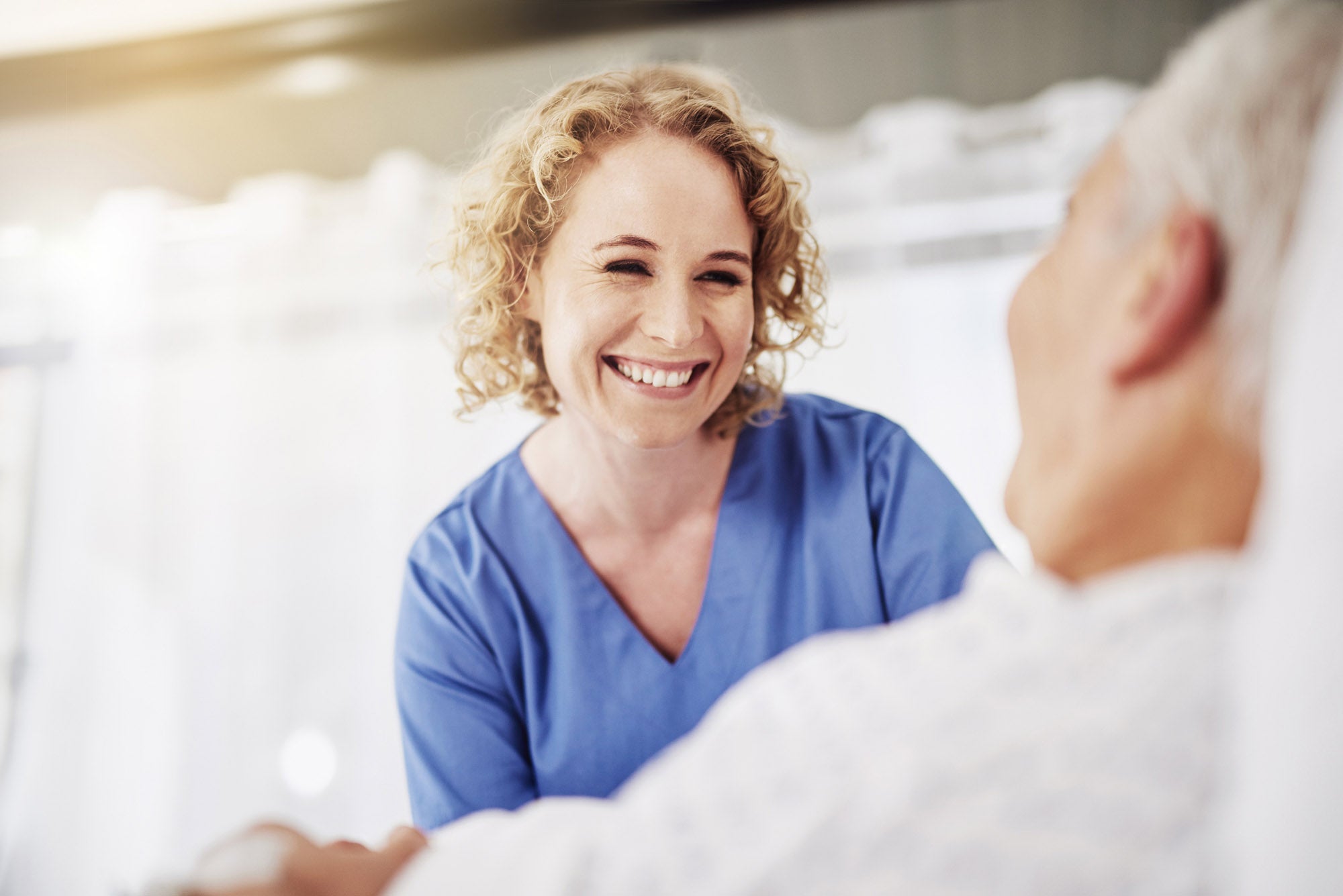 Shot of a female carer talking to her recovering male patient