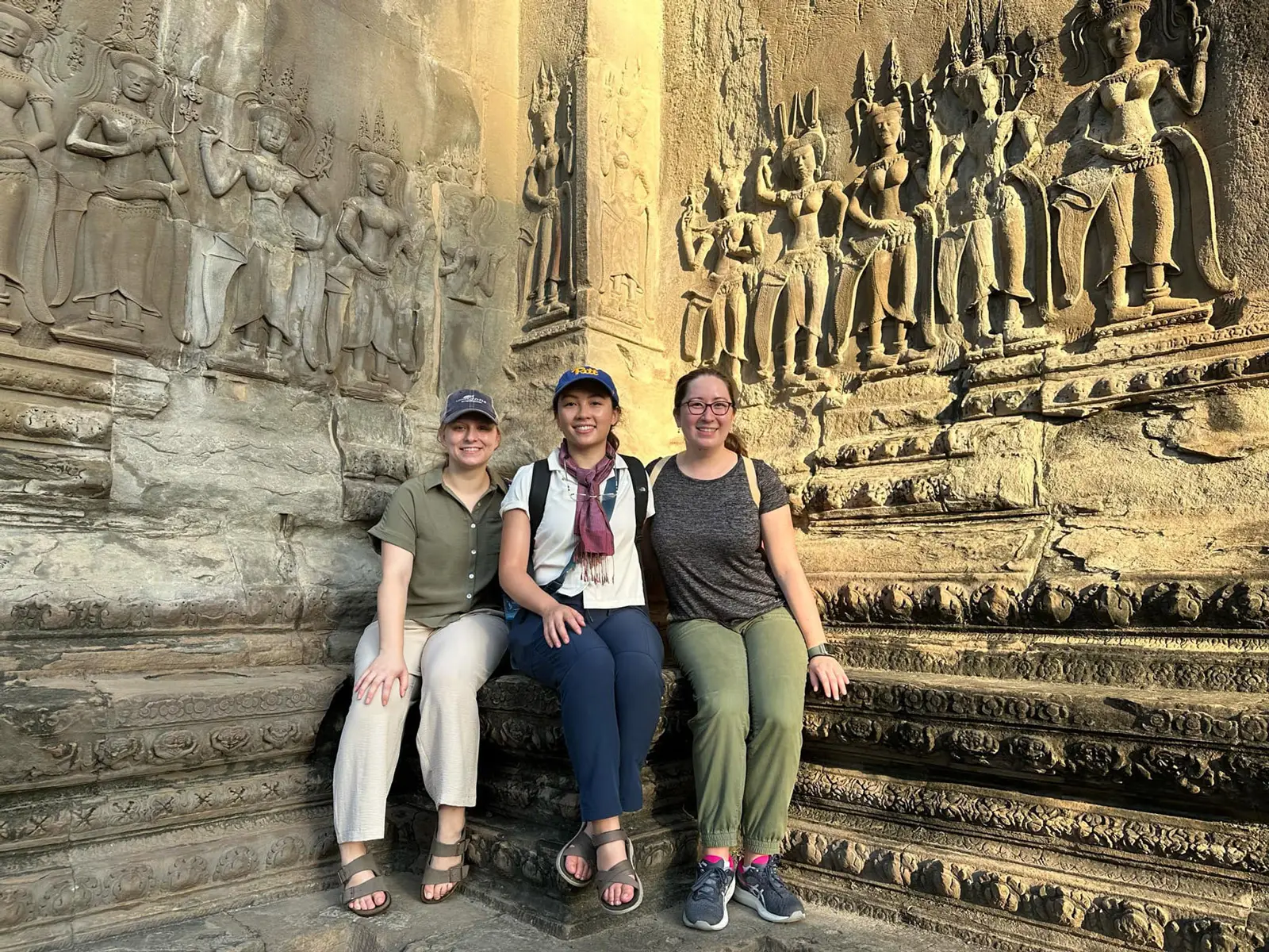 Three students posing in front of an historic landmark in Egypt.