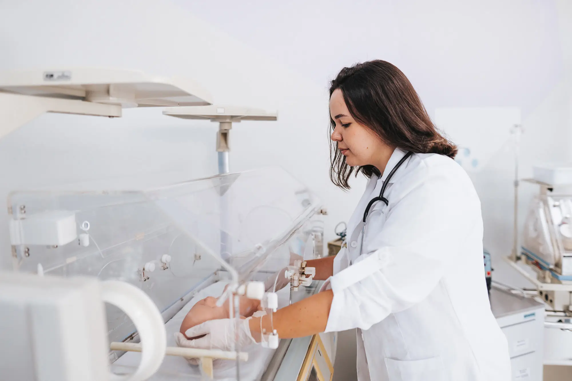 Medical student learning in incubator with doll